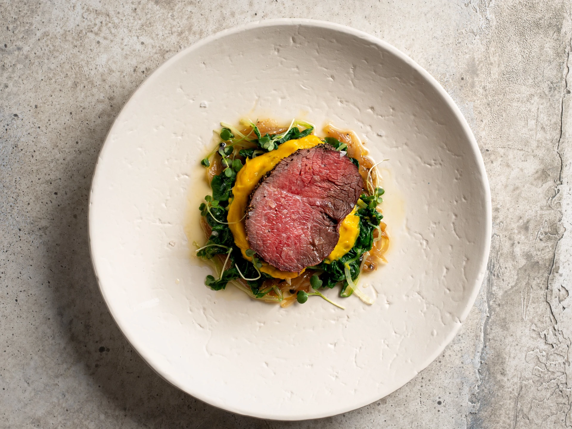 Filet Mignon Roast with Butternut Squash Cream, Sauteed Greens, and Tarragon Onion Beurre Blanc